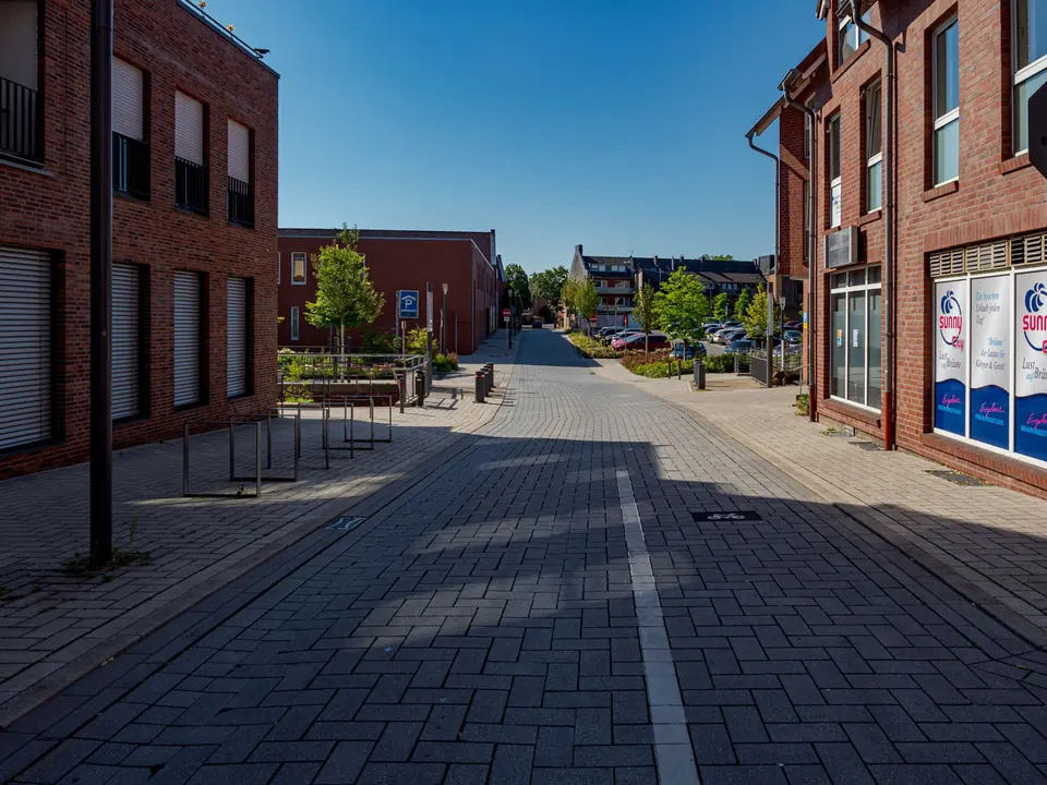 Friedliche Straße in Coesfeld, Deutschland, mit moderner Architektur und klarem blauen Himmel.